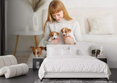 Young woman with her cute Jack Russell Terrier in a chair at home. white pet Wall mural