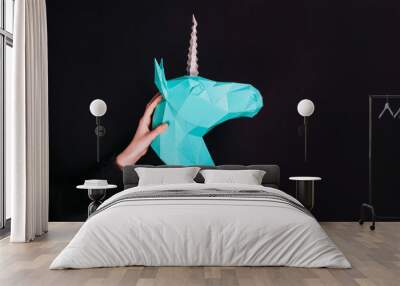 Hands hold a turquoise Unicorn. Artwork. 3d papercraft model of a unicorn. Wall mural