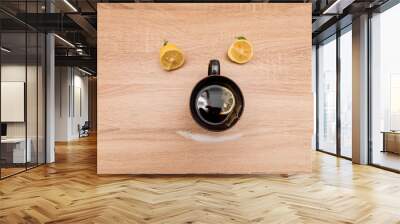 A mug with tea  lemons and sugar on a wooden table forming a smiling face Wall mural