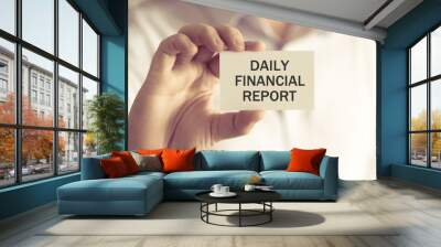 Businessman holding DAILY FINANCIAL REPORT message card Wall mural