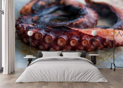 Closeup view over grilled octopus tentacles. Concept image of seafood on baking paper. Wall mural