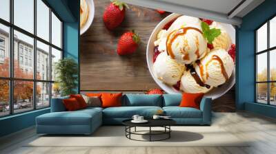 Top view of a bowl of vanilla ice cream with caramel sauce and strawberries Wall mural