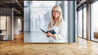 Beautiful portrait. Woman in white formal clothes is standing indoors Wall mural