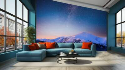 Beautiful winter landscape in the Carpathian mountains. Vibrant night sky with stars and nebula and galaxy. Deep sky astrophoto Wall mural