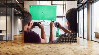 Beer on the table. Group of friends have fun playing console game indoors at living room Wall mural