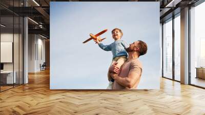 Blue sky with white cloud. Father is holding son that playing with toy plane Wall mural