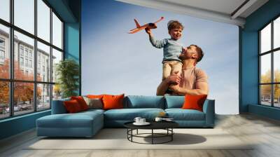 Blue sky with white cloud. Father is holding son that playing with toy plane Wall mural