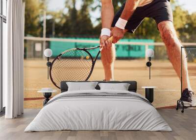 Close up view of senior man in white shirt and black sportive shorts that is on tennis court Wall mural