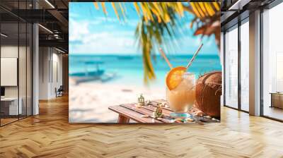 Cocktail in a coconut with straws and decor on the table, the ocean and a palm tree are in the background Wall mural