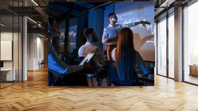 company growth plan. male leader talking to employees, showing information on the projector in offic Wall mural