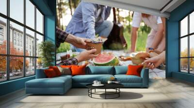 Conception of free time, wellness. Group of friends are having picnic on the field with food in eco boxes Wall mural