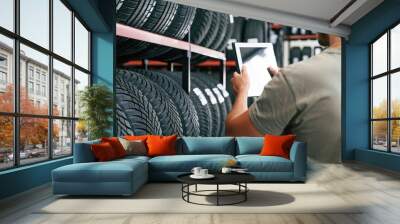 Copy space on the digital tablet. Man is in the tire fitting car service Wall mural