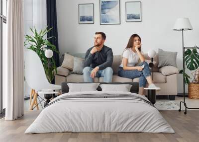 Couple sitting together on the sofa in domestic room Wall mural