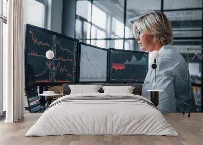 Female stockbroker in formal clothes works in the office with financial market Wall mural