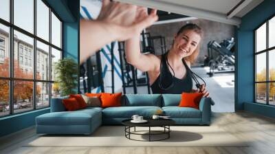 Friendly girl meets her friend. Photo of gorgeous blonde woman in the gym at her weekend time Wall mural