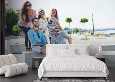 Group of people sitting on a staircase outdoors - Multiracial friends talking and having fun on a meeting outdoors on beach Wall mural