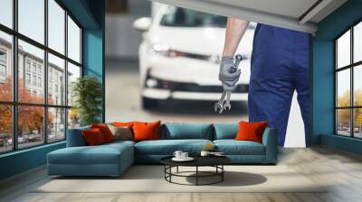 Hands of car mechanic with wrench in garage Wall mural