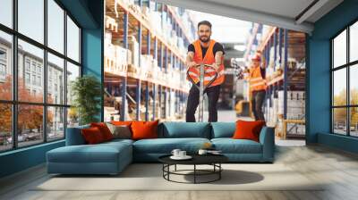 Having fun by using trolley platform. Two storage workers is in the warehouse Wall mural