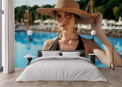 In the straw hat. Beautiful young woman is at resort, vacation Wall mural