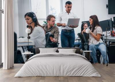 Inside of call center. Young business people working together in the modern office Wall mural