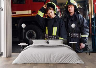 Male and female firefighters in protective uniform standing together Wall mural