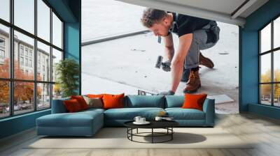 Man in grey uniform installing plate indoors in modern big office at daytime Wall mural