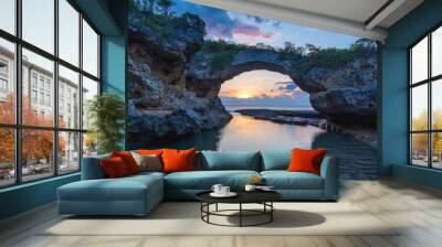 Natural bridge at dusk with vibrant sunset and tranquil water Wall mural