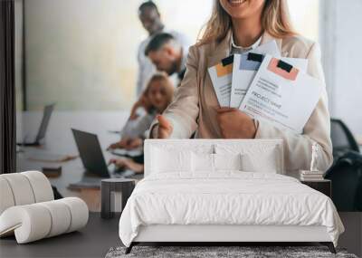 Project manager is standing with documents. Group of office workers are together indoors Wall mural