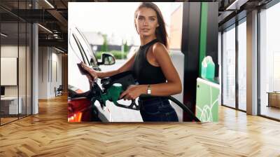 Refilling the vehicle. A young woman at a gas station with her car Wall mural