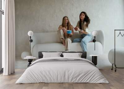 Tea and cookies. Two happy young female best friends are indoors Wall mural