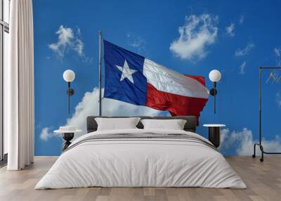 Texas flag waving boldly against a clear blue sky Wall mural