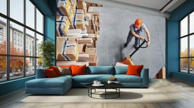 Top view of male worker in warehouse with pallet truck Wall mural