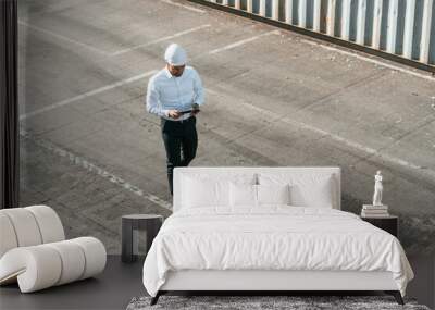 Top view. With tablet. Male worker is on the location with containers Wall mural