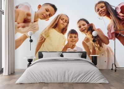 View from below of group of kids that looking down and having fun Wall mural