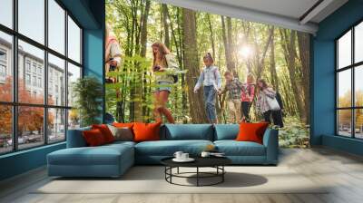 Walking together. Kids in green forest at summer daytime together Wall mural