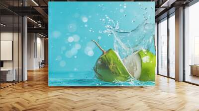 Water splashing out of a fresh green coconut isolated on a pastel summer blue background Wall mural