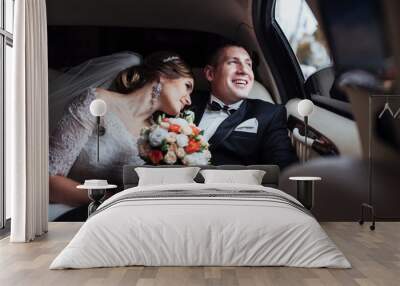 young couple in a car in wedding day. Wall mural