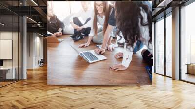 Young creative people in modern office. Group of young business people are working together with laptop. Freelancers sitting on the floor. Cooperation corporate achievement. Teamwork concept Wall mural