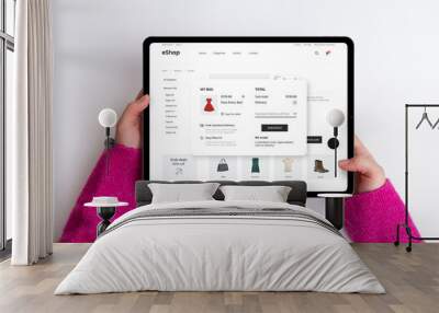 E-commerce cart page on a tablet with price, delivery options, and checkout button. Woman buys a red dress, creating a seamless and stylish online shopping experience Wall mural