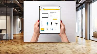 Modern electronic commerce web site on tablet in woman hands. Top view, flat lay scene. Concept of shopping online Wall mural