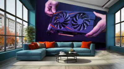 Mounting a modern graphic card to gaming computer. High performance graphics card with two coolers. The hands place the card in the computer case. Wall mural