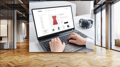 Woman purchasing a stunning red dress online with laptop computer. Modern ecommerce web page interface Wall mural