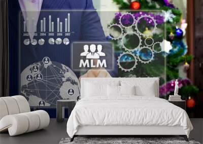 The businessman chooses MLM, multi-level marketing on the touch screen, the backdrop of the Christmas tree and decorations. Special toning Wall mural