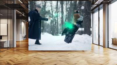 Battle of dark and light magicians with the help of magic wands and green beam. Wall mural