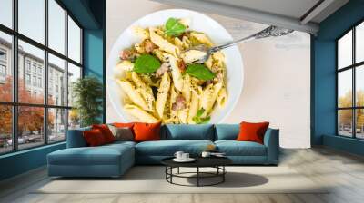 Mediterranean cuisine - penne pasta with pancetta, parmesan cheese and basil on a plate close-up, top view, copy space Wall mural