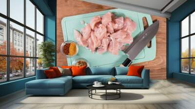 Sliced pieces of raw chicken breast and spices for cooking oriental cuisine on a cutting board with a Japanese knife. Cooking curry Wall mural