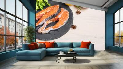 Two raw salmon steaks on a black plate with ingredients, close-up, copy space Wall mural