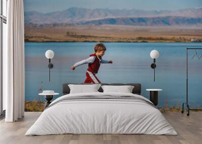 Active boy running on the lake shore Wall mural