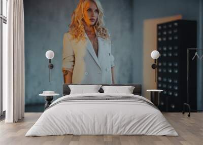 Young woman in white blazer fashion studio portrait at sunset light, tattoo on hand Wall mural