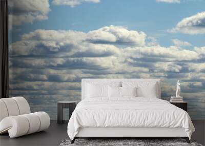 White fluffy clouds on a background of blue sky in summer. The concept of weather and climate. Wall mural